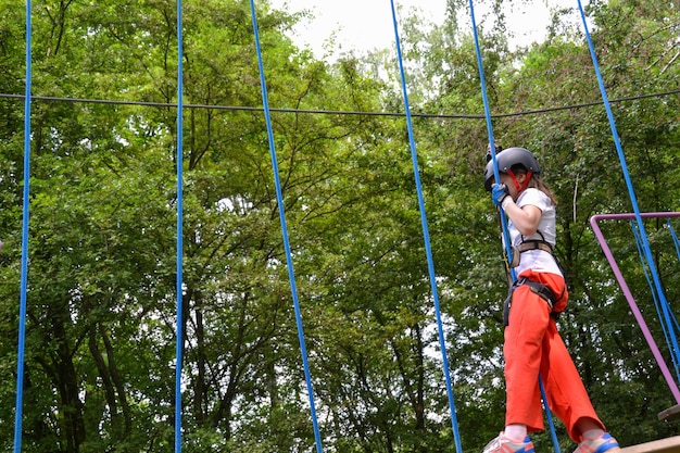 Photo aventure d'escalade sur les hauts fils des parcs des gens sur le parcours dans le casque de montagne et l'équipement de sécurité haut