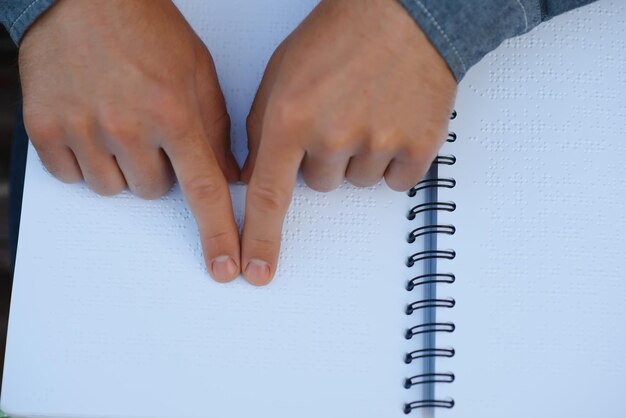 Photo aveugle lisant en touchant le livre en braille