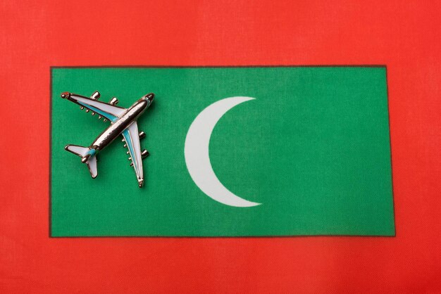 Avion au-dessus du drapeau du concept de voyage des Maldives