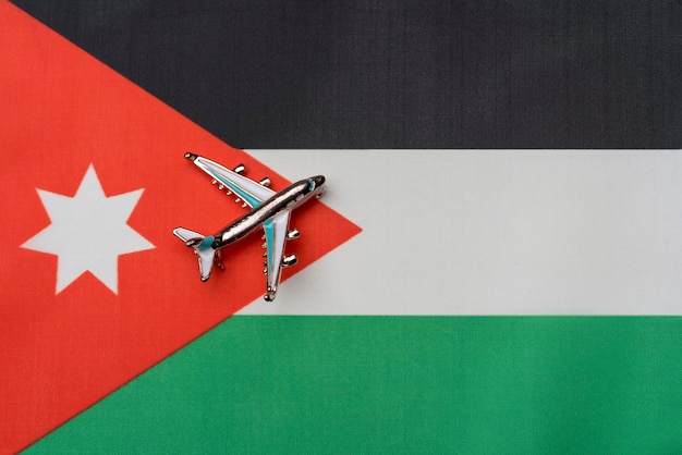 Avion au-dessus du drapeau de la Jordanie le concept de voyage