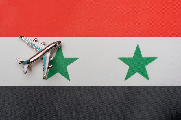 L'avion au-dessus du drapeau de la Syrie le concept de voyage