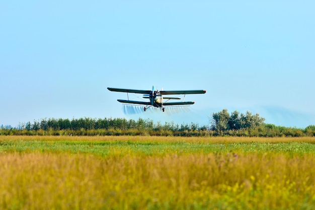 Avion d'aviation agricole qui arrose le champ des parasites