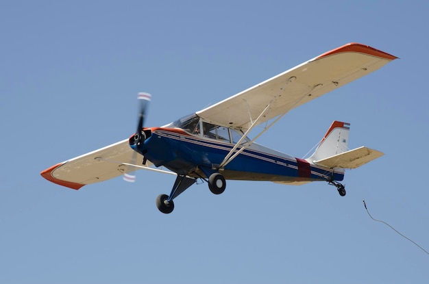 avion bleu et blanc volant avion à hélice volant remorquage planeur ultra-léger avion blanc et bleu volant