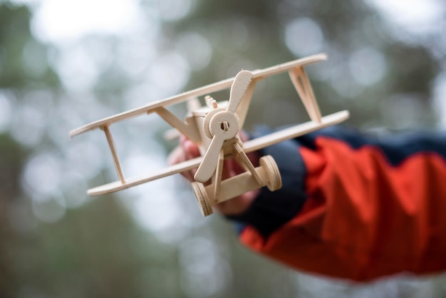 Un avion en bois entre les mains d'un enfant