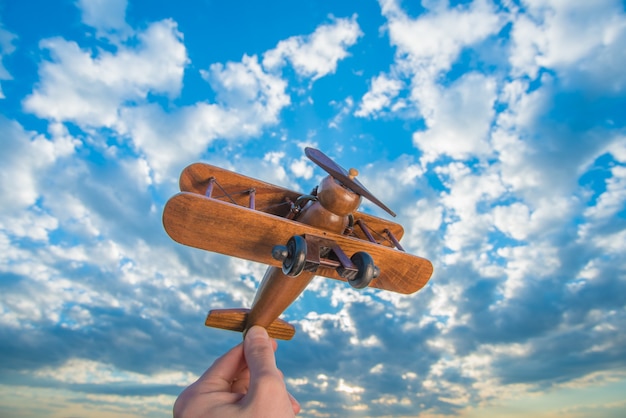 L'avion en bois de lancement de main sur le fond d'un ciel bleu