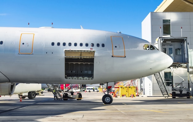 Avion debout dans le parking de l'aéroport, prêt à charger les bagages des passagers.