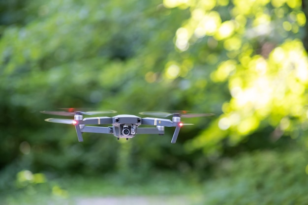 Avion drone avec hélices à rotation rapide floue et appareil photo volant dans les airs.