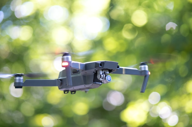 Avion drone avec hélices à rotation rapide floues et appareil photo volant dans les airs.