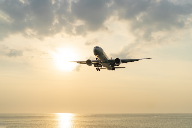 L'avion Est Assis Au-dessus De La Mer Au Coucher Du Soleil.