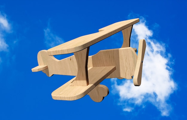 Avion jouet en bois 3d sur un ciel bleu