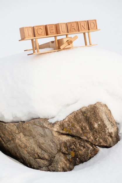 Un avion jouet en bois et le pays d'Islande, composé de leurs cubes sur fond de montagnes enneigées. Le concept de voyager dans les pays du nord de l'Europe, en Islande