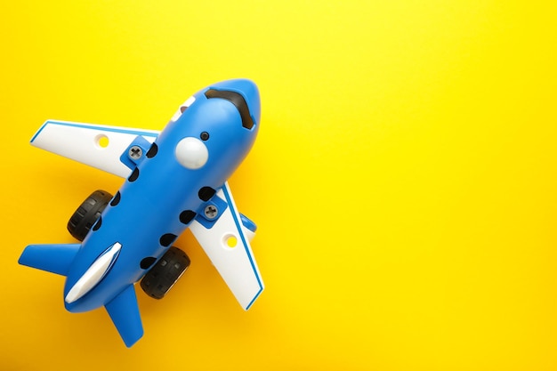 Avion jouet en plastique sur fond jaune avec place pour texte