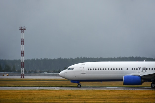 L&#39;avion de ligne a atterri sur la piste de l&#39;aéroport par mauvais temps avec la pluie