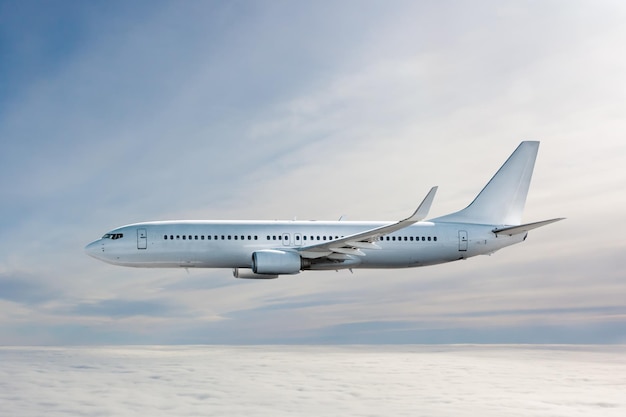 Un avion de ligne blanc vole dans les airs au-dessus des nuages