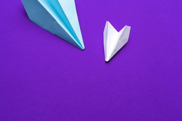 avion en papier blanc sur un violet