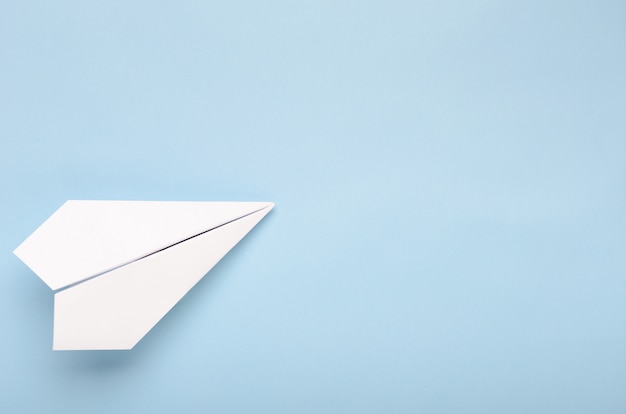 Photo avion en papier sur un fond bleu.