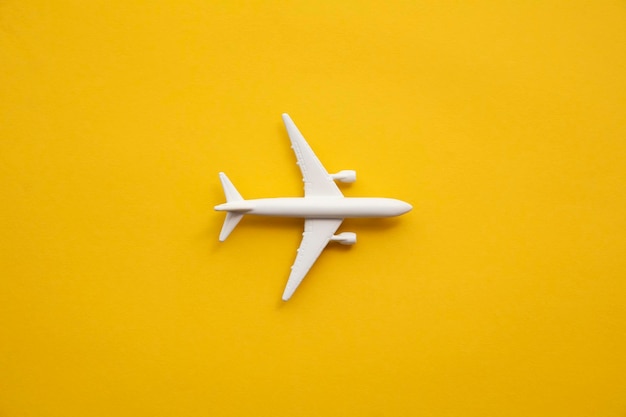 Avion de passagers blanc sur fond jaune d'été. Fond de voyage et de vacances.