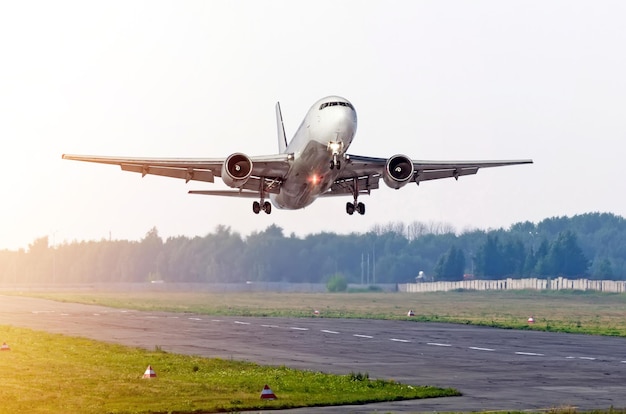 L'avion de passagers décolle au soleil sur une piste.