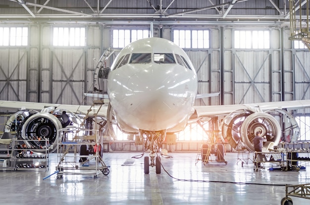 Avion de passagers sur l'entretien du moteur et la réparation du fuselage dans le hangar de l'aéroport.