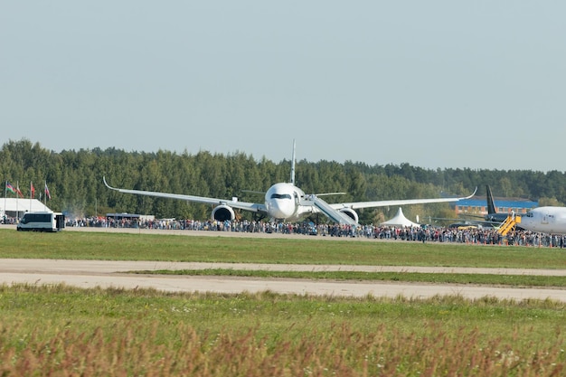 Un avion de passagers sur l'exposition en plein air d'avions personnes se tenant devant lui