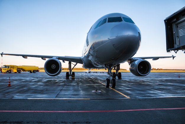 Avion de passagers sur le tablier de l'aéroport près du pétrolier