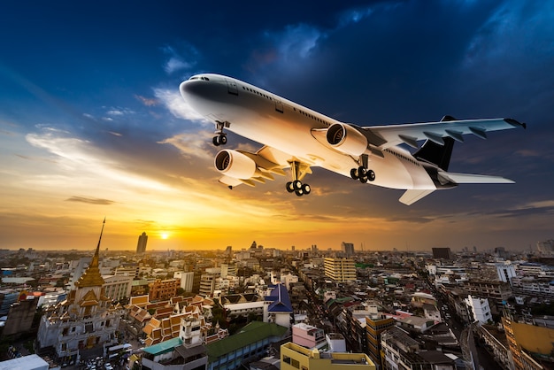 Avion pour le transport survolant la ville sur fond magnifique coucher de soleil