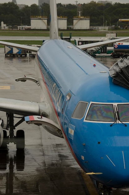 avion avec putesa manche au moment du ravitaillement en carburant et l'entrée des passagers à l'aéroport un jour de pluie