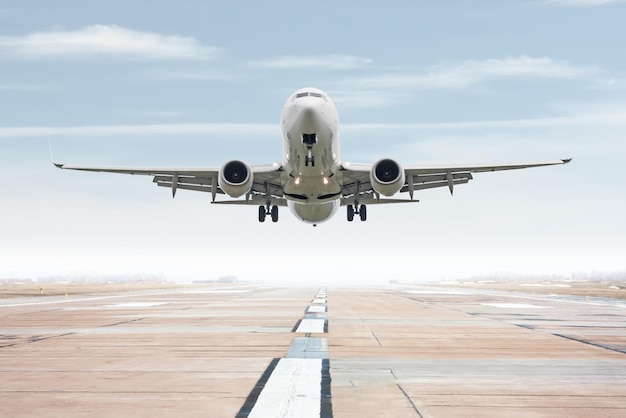 Un avion à réaction blanc décolle de la piste de l'aéroport