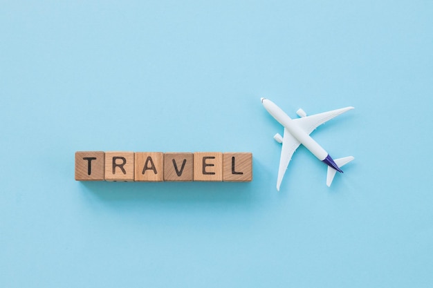 Avion à réaction et concept de voyage de voyage de mot art minimal sur fond bleu