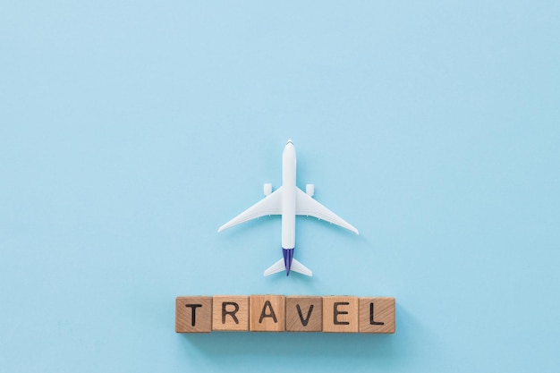 Avion à réaction et concept de voyage de voyage de mot art minimal sur fond bleu