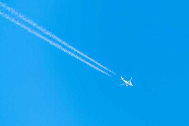 Un avion à réaction haut dans le ciel bleu Un avion de ligne dans le ciel Laisse des traces d'air blanc Voyageant sans frontières