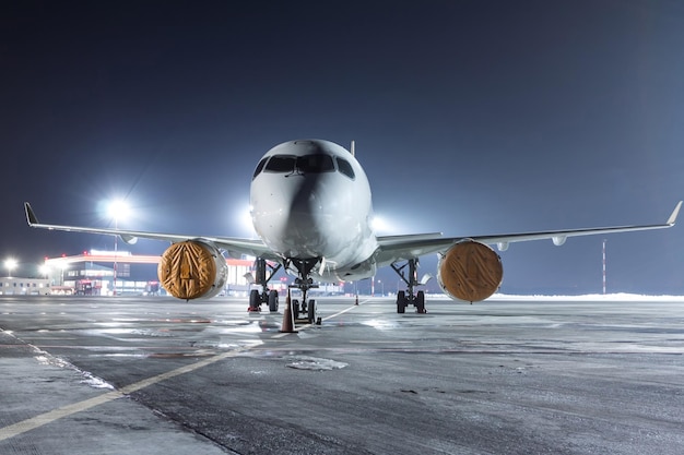 Avion à réaction moderne sur le tablier de l'aéroport de nuit