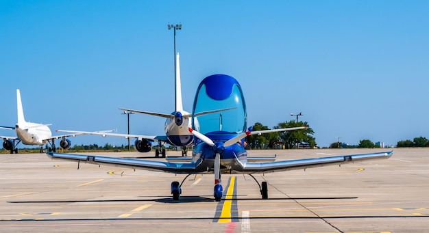 Avion de sport bleu brillant sur la piste ensoleillée de l'aéroport