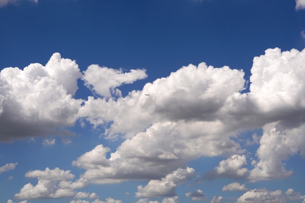 Avion survolant les nuages dans les fonds de ciel bleu