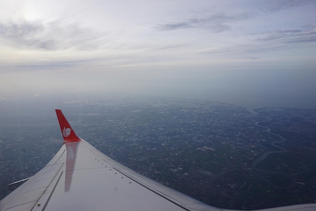 Photo un avion survolant un paysage contre le ciel