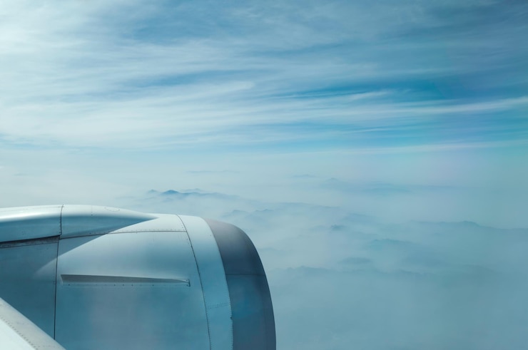 Photo un avion survolant un paysage nuageux contre un ciel bleu