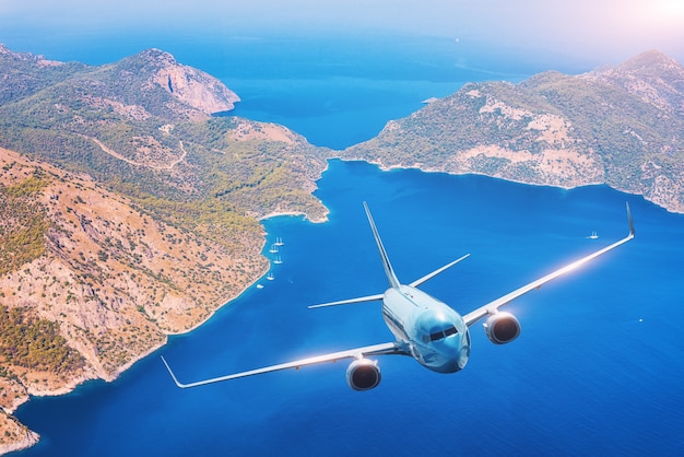 L'avion survole les îles et le bord de mer au coucher du soleil en été.