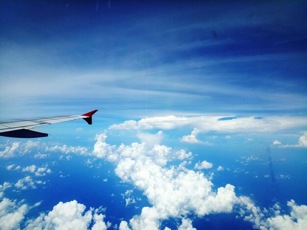 Photo un avion volant au-dessus des nuages contre le ciel bleu