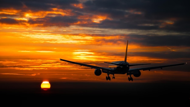 Un avion volant dans le ciel au coucher du soleil