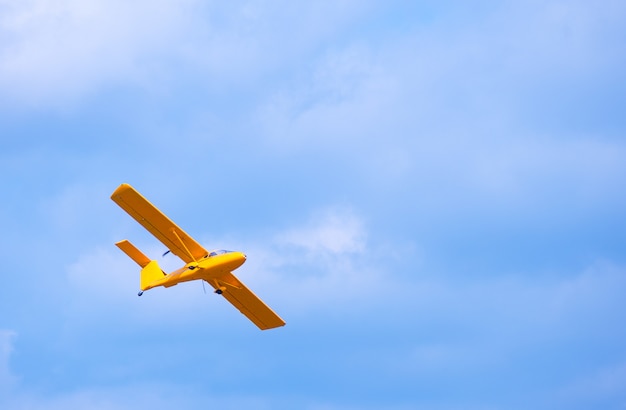 Avion volant lumineux jaune dans le ciel bleu