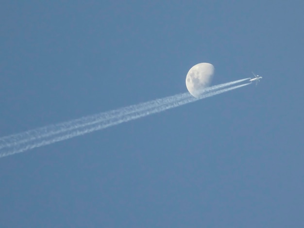 L'avion volant près d'un disque de la lune