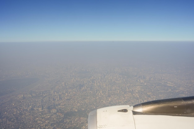 Un avion vole dans le ciel au-dessus d'une ville.