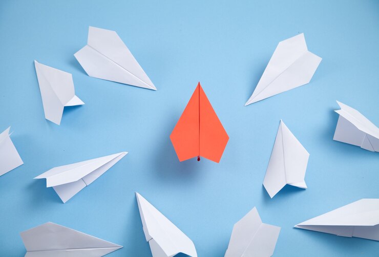 Photo avions en papier rouge et blanc sur fond bleu. leadership. travail en équipe