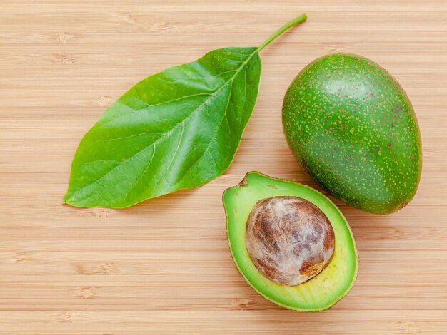 Photo avocado frais sur fond de bois avocado biologique concept alimentaire sain avocado sur planche à couper en bambou l'avocado est populaire dans la cuisine végétarienne et le contrôle du poids