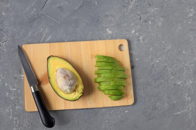 Photo un avocado sur une table en bois blanc