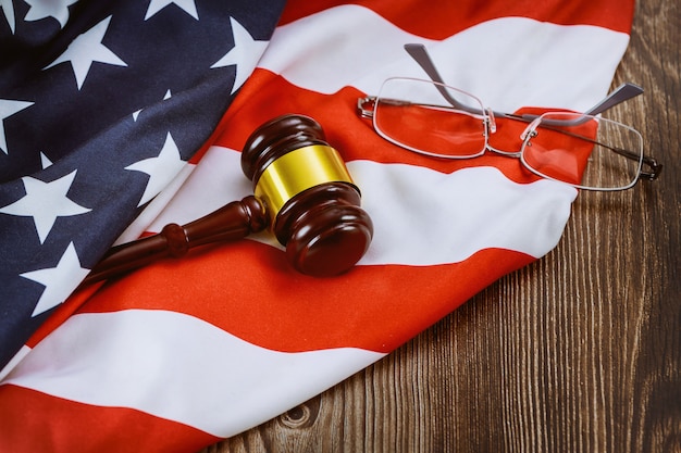 Photo avocat de bureau de la justice à table travaillant le juge en bois marteau et lunettes sur le drapeau américain