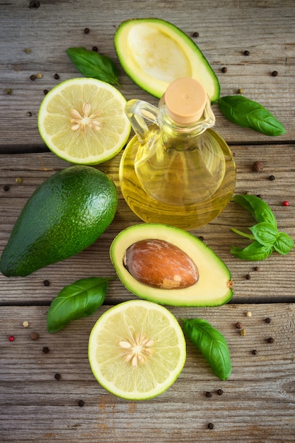 Avocat, citron vert, huile d'olive et épices sur vieux bois