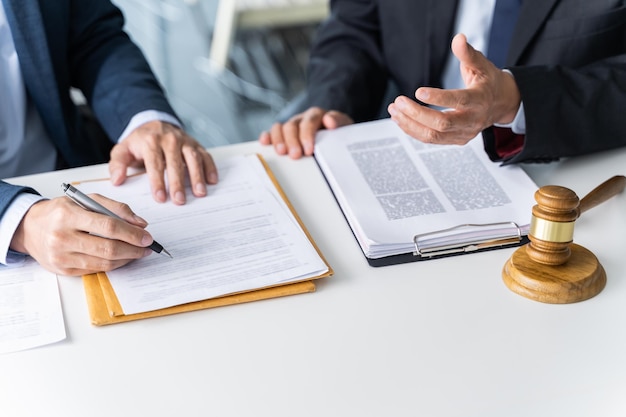 Avocat Le conseiller juridique présente au client un contrat signé avec le marteau et le droit juridique justice et avocat Concept de réunion de partenariat d'affaires
