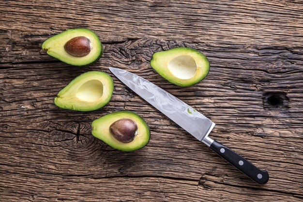 Avocat. Couper l'avocat sur une table de fond en bois de chêne. Mise au point sélective.