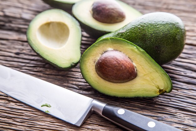 Avocat. Couper l'avocat sur une table de fond en bois de chêne. Mise au point sélective.